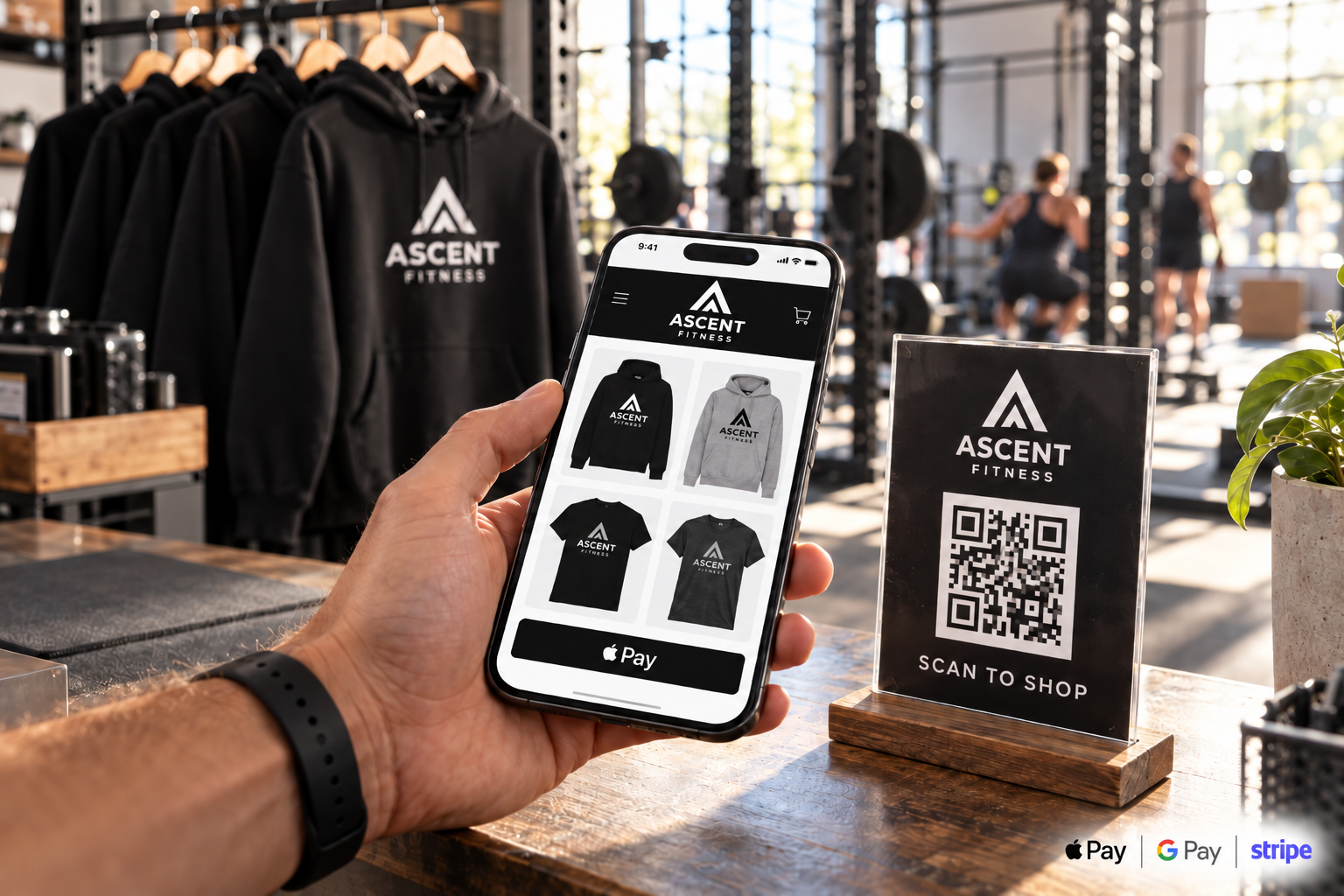 A hand holding a phone showing a gym's online apparel store next to a QR code scan-to-shop sign
